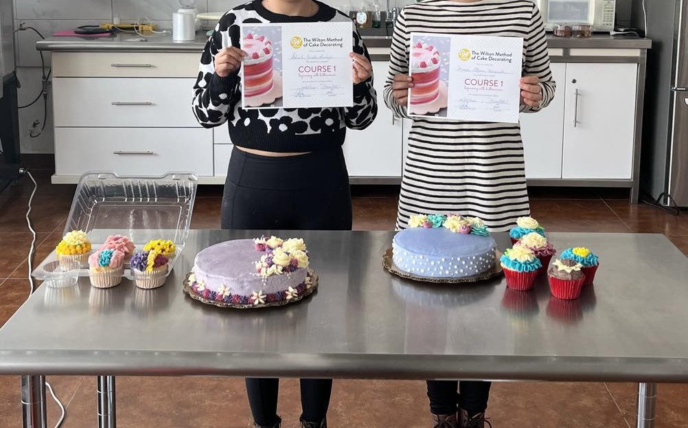Variedad de pasteles y rollos exhibidos por alumnos